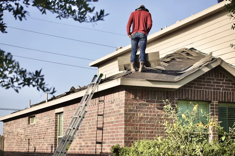 Professional roofer working on a residential roof in Norma